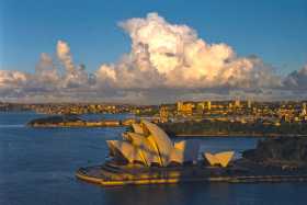 Sydney Harbour Bridge casts its shadow on the Opera House, glowing in the evening sunshine Sydney Harbour Bridge casts its shadow on the Opera House, glowing in the evening sunshine