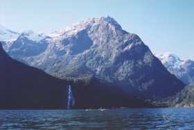 Sea-kayaking on Milford Sound with Bowen Falls in the distance Sea-kayaking on Milford Sound with Bowen Falls in the distance